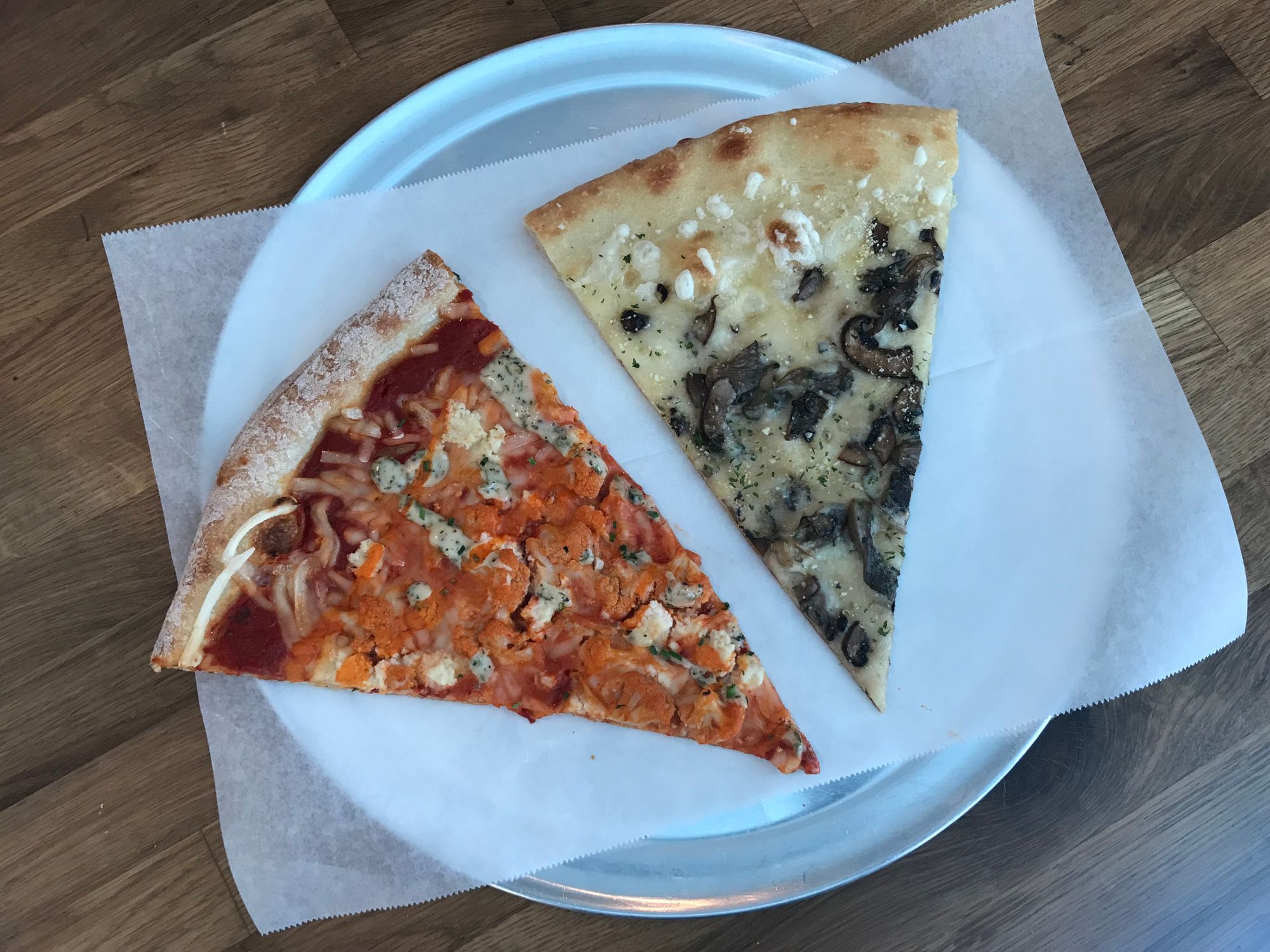 A slice of buffalo cauliflower and their pizzeria's class screamer. (Photo: Kadia Goba/Bklyner)