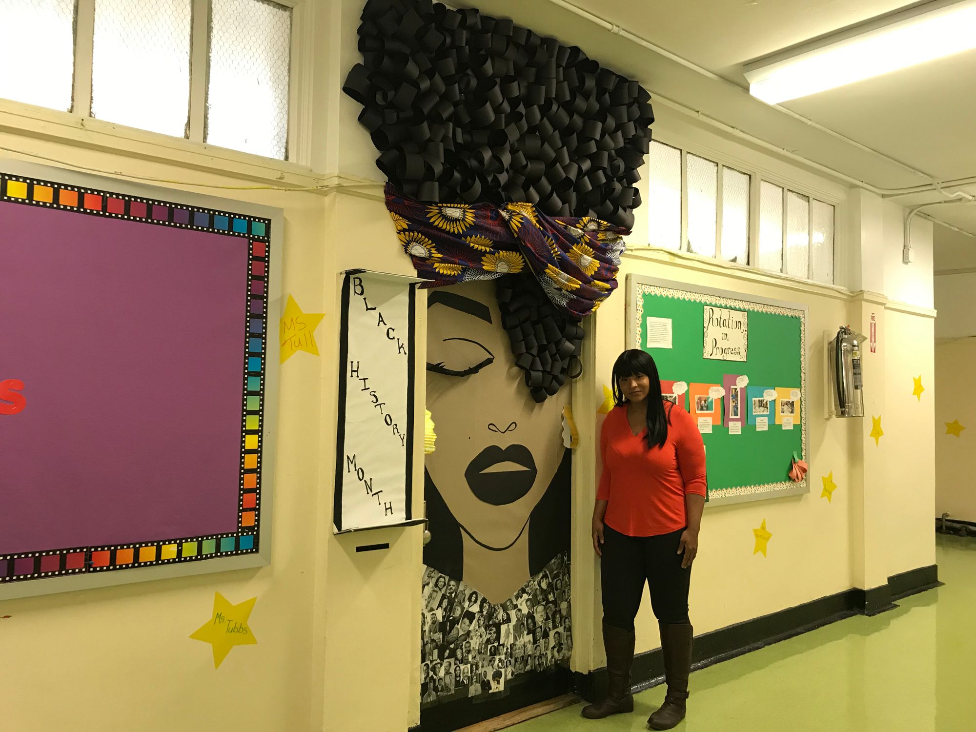 Hollie Tubbs standing next to her Door Art at PS 231 at 54 in Bedford Stuyvesant. The assistant teacher wanted to create an inspiring piece for Black History Month. (Photo credit: Kadia Goba/Bklyner)