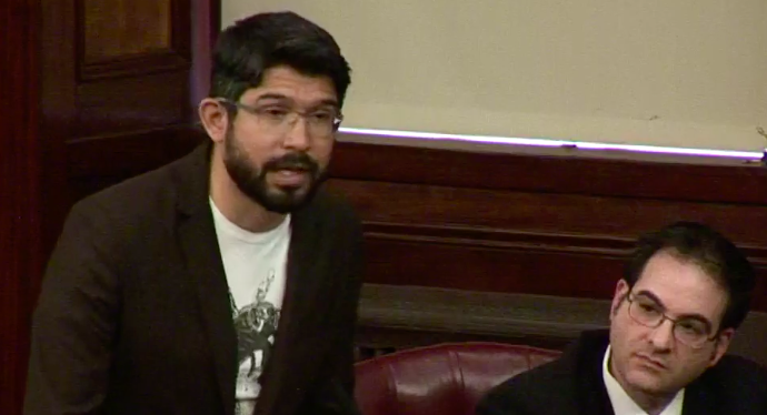 Councilman Carlos Menchaca explaining his vote to oust Councilman Kalman Yeger as the Boro Park lawmaker looks on. (Screenshot: City Council hearing video)