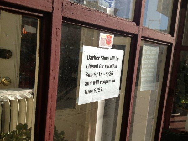 Photo of a sign announcing summer vacation at Vincent's Barber Shop