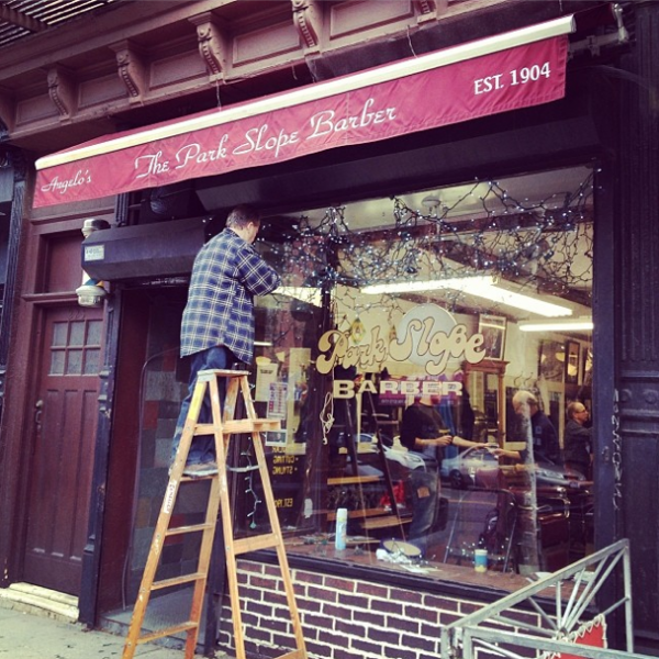 Park Slope Barber putting up holiday lights