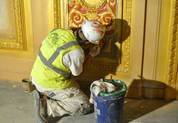 worker painting molding at Kings Theatre 