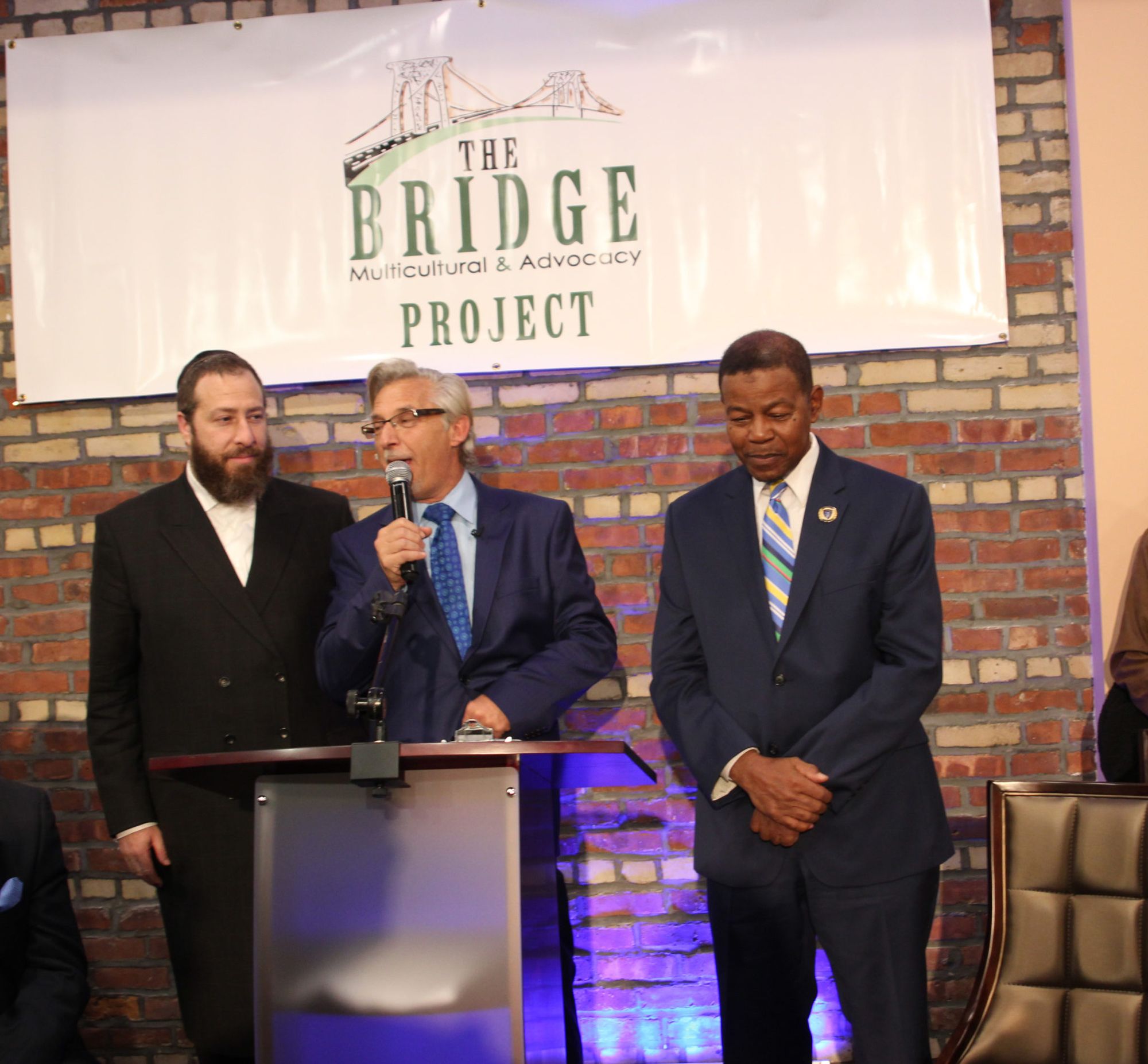 Founder of the Bridge Community Center Mark Meyers Appel, center, presents Ezra Fieldlander, CEO of the Friedlander Group, left, and District Leader Ed Powell with the Hero's Award.