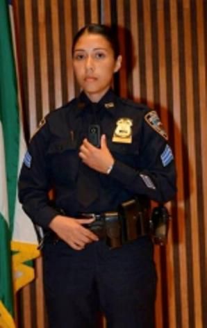 Sergeant Andrea Cruz, demonstrates the LE3, a pager size camera worn on the front of an officer’s shirt. Photo via the NYPD.