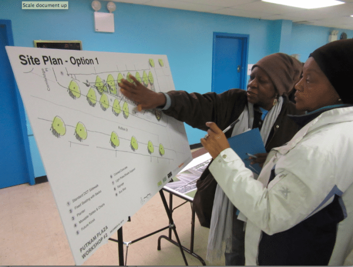 Odessa Hall and Geraldine Hernandez of Clinton Hill examine the redesign options for Putnam Triangle Plaza. 