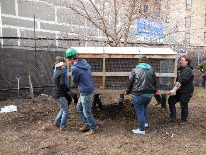 Volunteers carry the compost bin during the Q Gardens inaugural cleanup day. Photo by Nathan Thompson