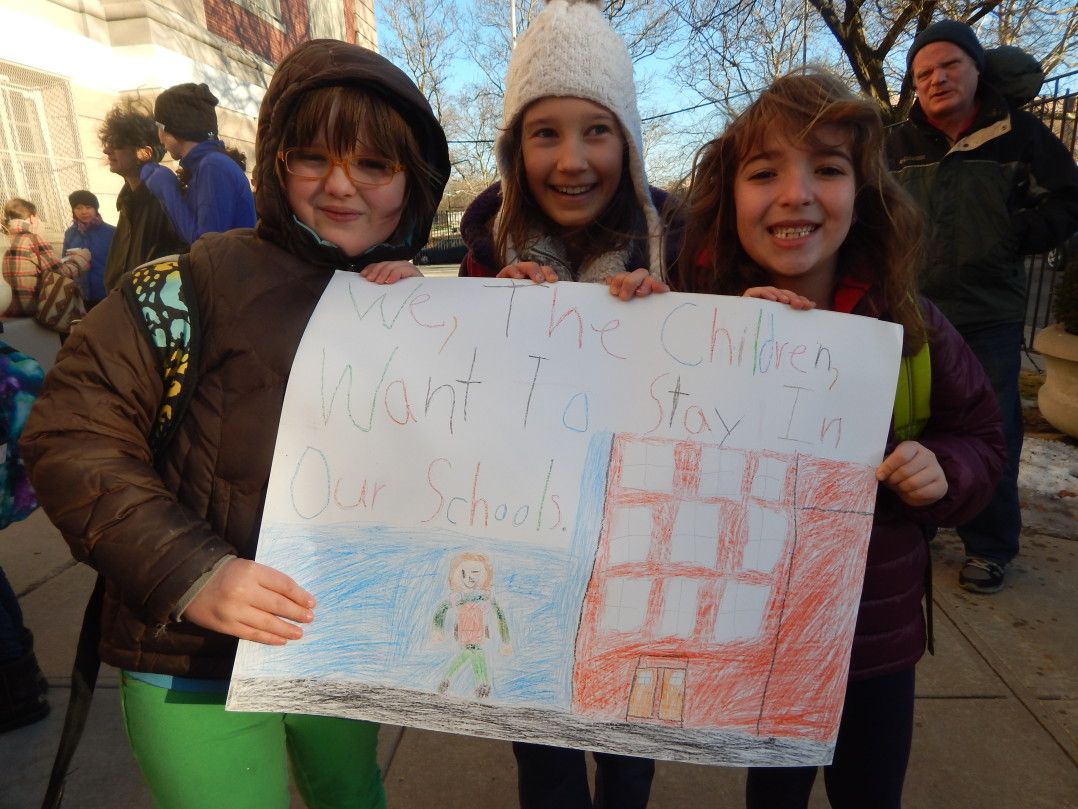 PS 130 students with a sign made by Nora Crean, 8, far left.