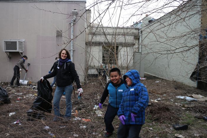 Neighbor Anne Schoeneborn and two younger volunteers work to clean up Q Gardens on Saturday. Photo via Q Gardens.