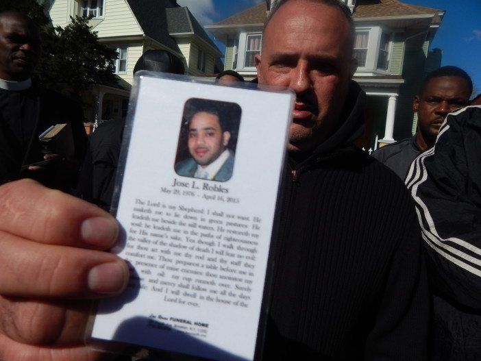 Raul Marroquin holds the prayer card for Jose Robles, who he grew up with and considered to be like a brother.