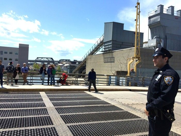 An NYPD officer manages the crowd of gawkers.