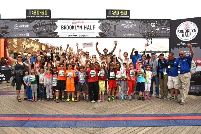 Courtesy of NYRR. (At the finish line of the 2015 Airbnb Brooklyn Half Marathon, Brooklyn School of Inquiry's 2nd graders, teachers, and parents are joined by incoming NYRR Co-Presidents Peter Ciaccia [far-left in blue polo shirt] and Michael Capiraso [far-right in jeans] along with NYRR staff).