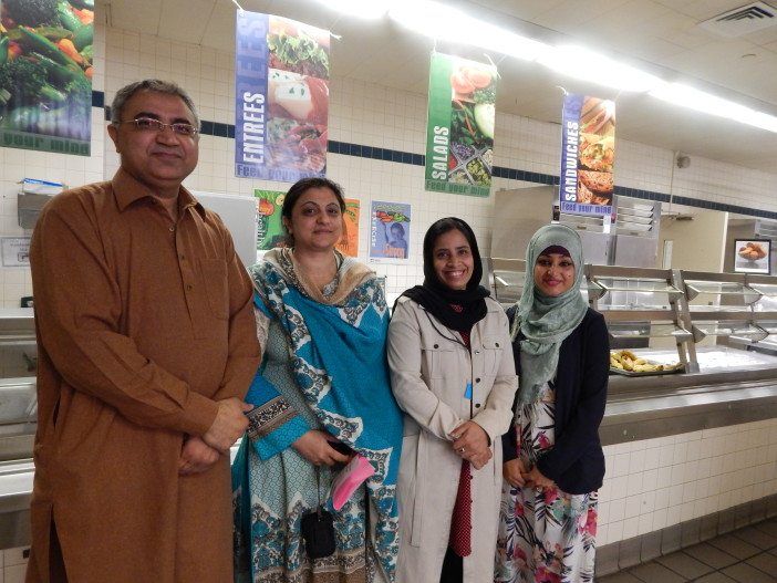 (From left to right) PS 217 parents and PA members Shahid Khan, Nazia Shahid, Mukta Begum, and Tazin Azad stand before the cafeteria's serving line, where the new food dishes will be served today.