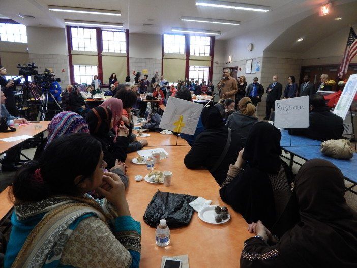 Neighbors listen to PS 217 parent and PA member Shahid Khan translate the event's statements into Urdu.