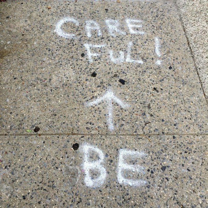 writing on sidewalk in south slope reading "be careful"