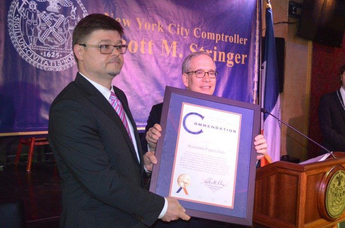 A Brooklyn resident receiving an award from the comptroller.