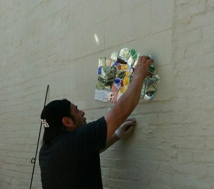 Juan Carlos Pinto begins the mosaic at Q Gardens. Photo via Q Gardens