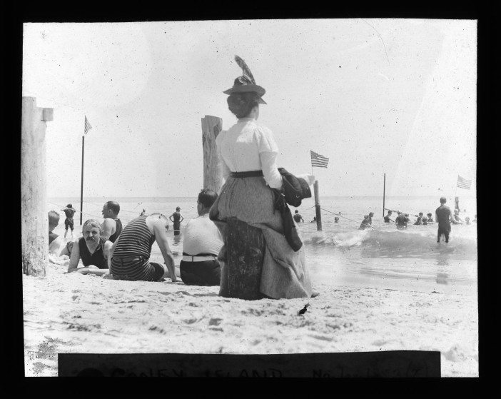 a woman not exactly dressed for beach weather at coney island