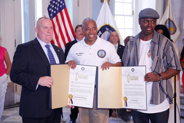 Brooklyn Borough President Eric L. Adams recognizes retired NYPD Detective Richard Lyman (left), who helped solve a 12-year-old murder case in Flatlands, and Iver Whittingham (right), a Good Samaritan who tried to stop a fight between teenage girls at a McDonald’s in Fort Greene, as “Heroes of the Month” for July during a ceremony in Brooklyn Borough Hall. (Photo by Malcolm McDaniel/Brooklyn BP’s Office)