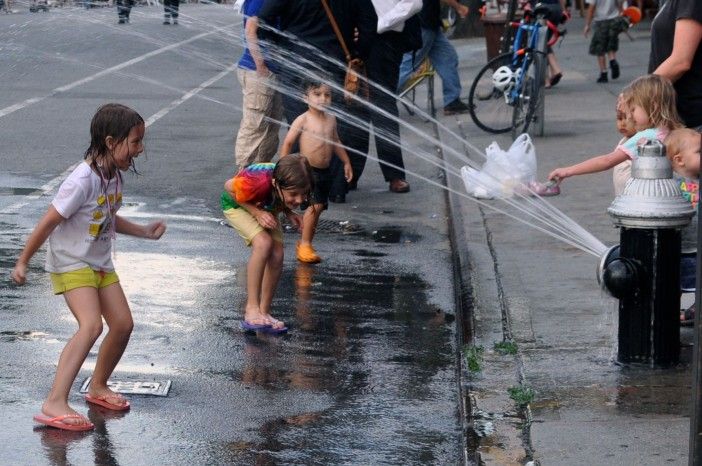 kids cool off in the spray of a fire hydrant in brooklyn