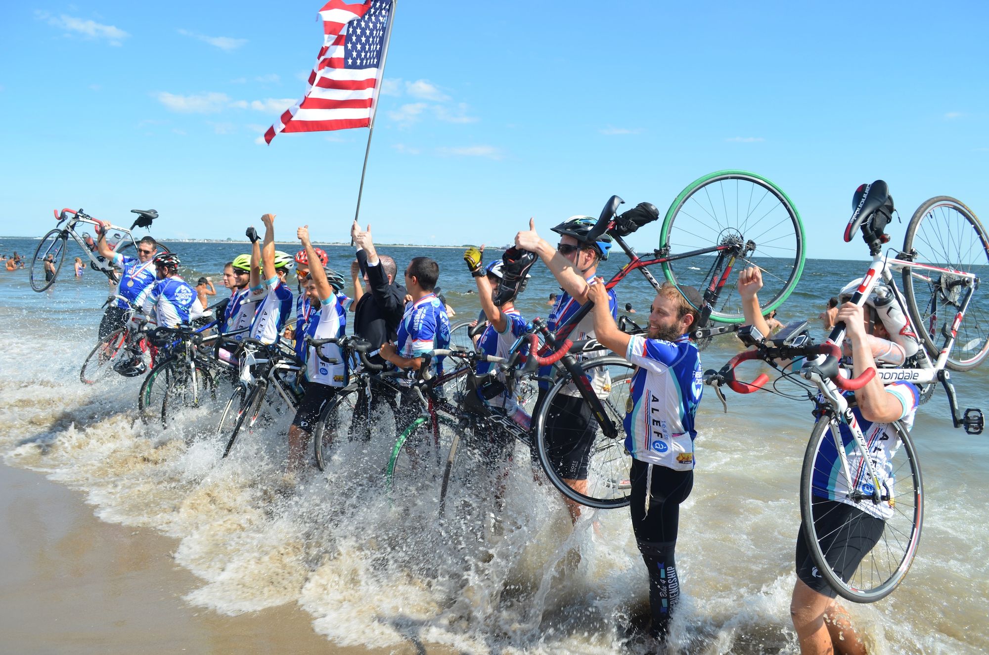 The Bike 4 Friendship men's team hold their rides above the surf. 