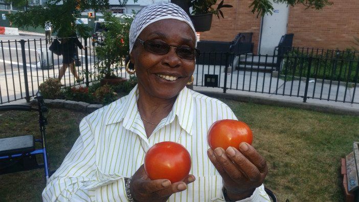 Aretha Singleton shows off some of her garden-grown produce. (Photo by Fort Greene Focus)