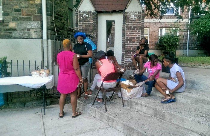 Neighbors prepare for a dinner outside with Jadann's family as part of nine nights. (Photo by Shannon Geis/Ditmas Park Corner)
