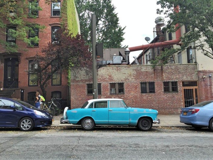 an old blue car parked on a side street in park slope