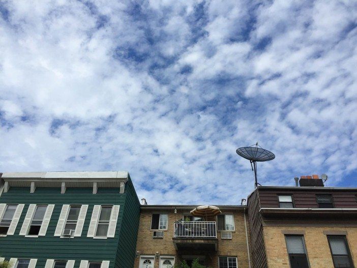 blue sky and clouds over south slope apartment buildings