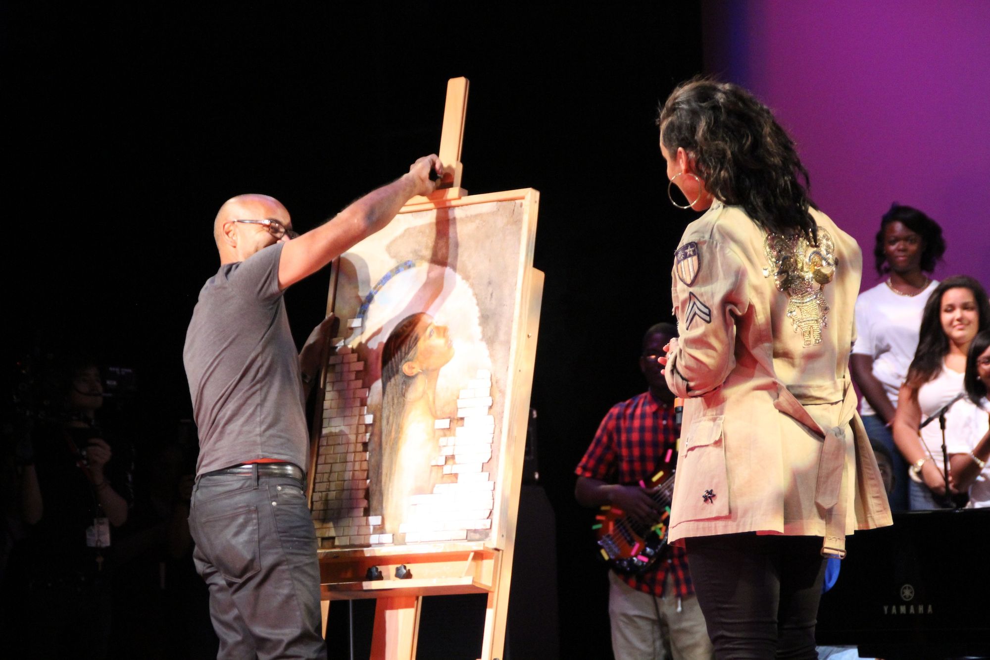 Art Teacher Carlos Rosado gives Alicia Keys a portrait as a thank you.