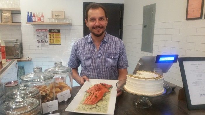 Saucy By Nature owner Przemek Adolf at the store's counter on their first day. (Photo by Heather Chin / Fort Greene Focus)