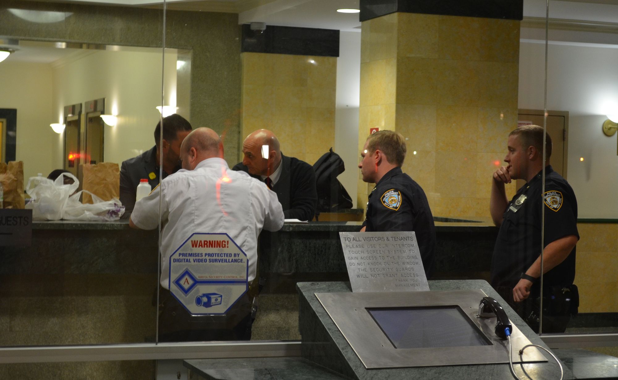 Police and building staff speaking in the lobby while the building was on lockdown. (Photo: Alex Ellefson