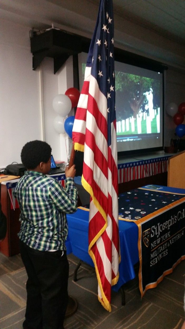 Veteran Hardee Smallwood's great-grandson, holding the American flag at the Veteran's Day ceremony. (Photo by Fort Greene Focus)