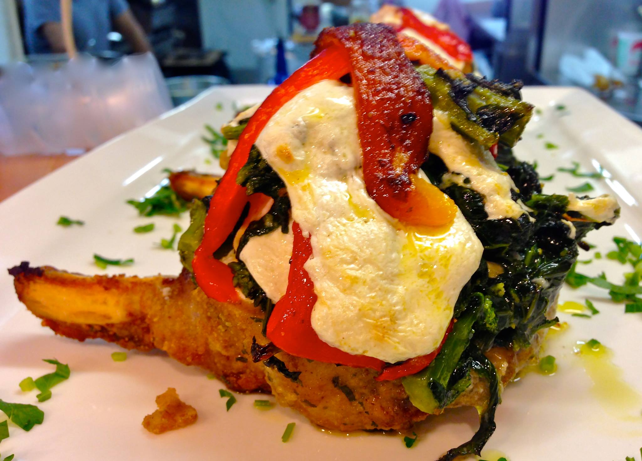 Slow roasted pork chop topped with Brocoli Rabe, fire roasted peppers and homemade mozzarella. (Photo by The Family Store/Facebook)