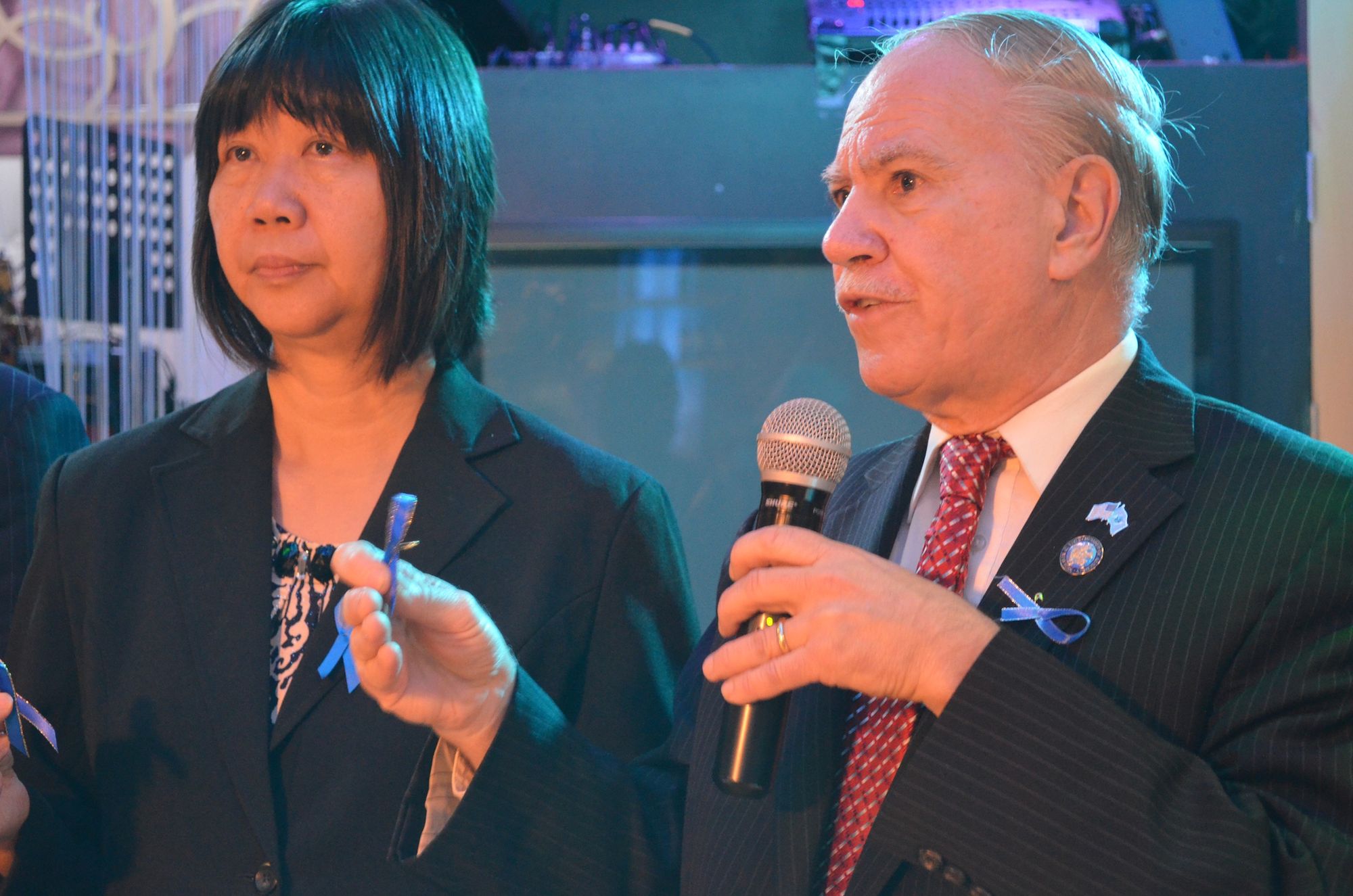 Assemblyman William Colton and District leader Nancy Tong holing their police ribbons. 