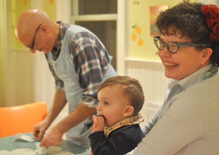 Joe Famiglietti and Nicole Francis (with a friend's baby) bake cookies for the Coalition for the Homeless. (Photo by Mary Bakija/Ditmas Park Corner)