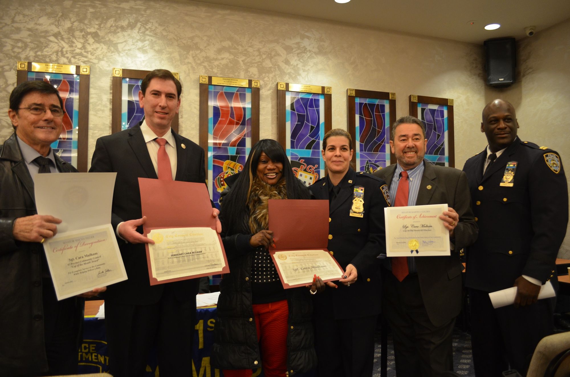 Sergeant Cara Mulham receiving awards from councilmen Chaim Deutsch and Mark Treyger and senators Marty Golden and Simcha Felder.