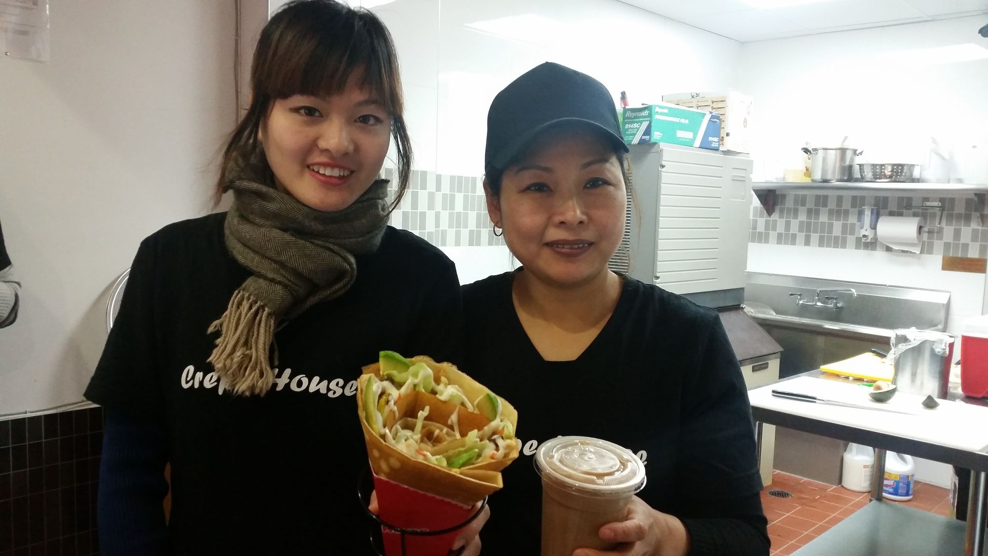 It's a family business at Crepe House: mom Bi Chen (right) and Jenny Chen prepare to serve a savory chicken crepe and milk bubble tea. (Photo by Heather Chin/Fort Greene Focus)