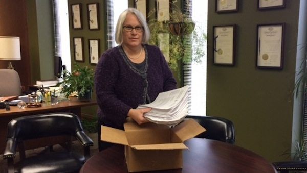 Assemblywoman Helene Weinstein holding letters and signatures opposing the Bragg Street halfway house. (Photo provided by Weinstein's office)