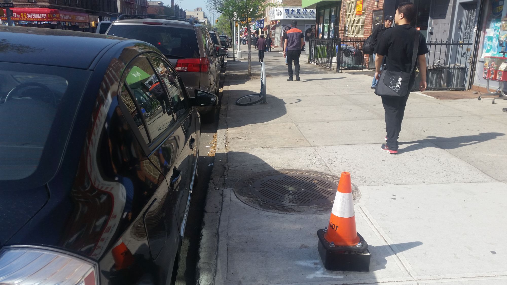 A traffic cone and letter "M" marks the spot where a MuniMeter will go on 7th Avenue in Sunset Park. (Photo by Heather Chin/Sunset Park Voice)