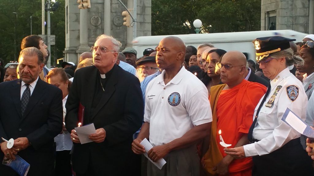 Brooklyn Bishop Nicholas DiMarzio and Brooklyn Borough President Eric L. Adams stand with police and religious leaders to pray for shooting victims in Grand Army Plaza. (Elizabeth Elizalde / Sunset Park Voice) 