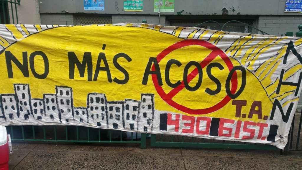 A banner made by Neighbors Helping Neighbors that says,"No más acoso" in Spanish, which translates to "No more harassment" in English. (Photo: Elizabeth Elizalde / Sunset Park Voice)