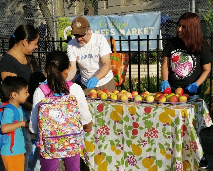 The Flatbush Food Co-op gave 150 organic apples to children returning to PS 139. (Photo courtesy Flatbush Food Co-op)