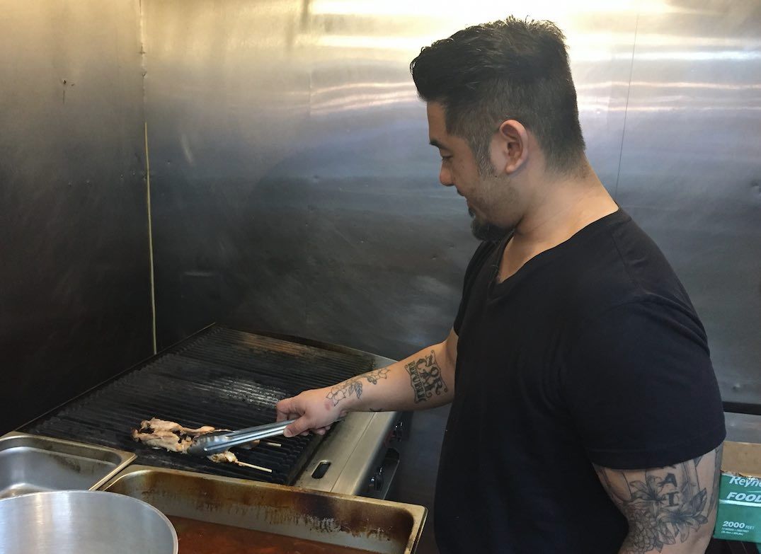 Chef Armando Litiatco grilling chicken skewers on the lava rock grill.