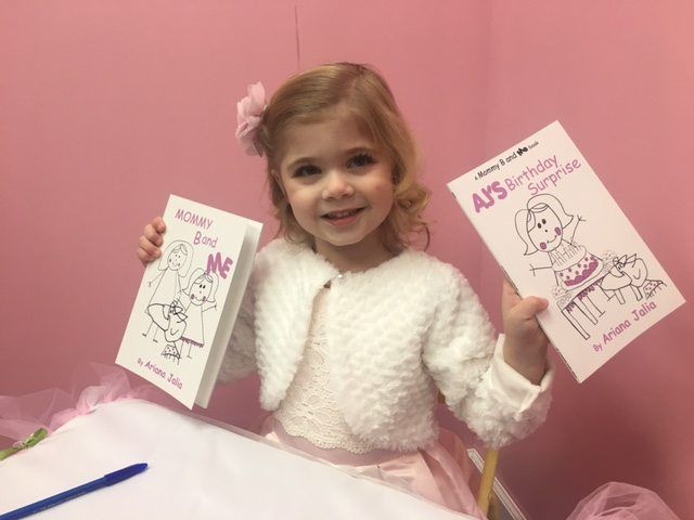 Ariana holding her two books, Mommy B and Me and AJ's Birthday Surprise. Photo by Sean Egan/Sheepshead Bites.